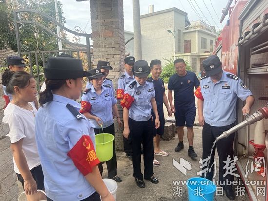 民輔警跟隨消防水車作業(yè)，通過肩挑手提的方式將清水送入行動不便的老年、殘障村民的家中（通訊員 李麗君 攝） (3).jpg.jpg